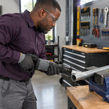African American facilities technician uses a reciprocating saw fitted with an NRG 150mm metal blade to cut a supported steel pipe.