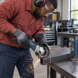 African American metal fabricator using a guarded angle grinder with the NRG 115 mm diamond disc to cut square steel tubing.