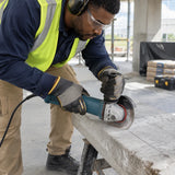 Building-renovation installer using an NRG 115mm diamond disc on a guarded angle grinder to cut reinforced concrete