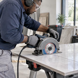 African American tile installer using compatible 230mm cutting equipment fitted with an NRG diamond disc to trim ceramic tile