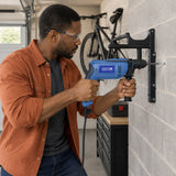African American homeowner using a Pirana PSR650RK percussion drill to make a masonry fixing hole for a bicycle rack in a garage.