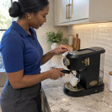 African American adult fitting a portafilter and preparing a single espresso with the black Kaiser Empire coffee machine at home