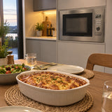 Finished browned meal served beside a contemporary kitchen with the Kaiser EM 2520 built-in stainless microwave visible in the background