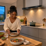 Finished meal beside a settled cooktop beneath the Kaiser EA 644 Eco cooker hood in a calm contemporary kitchen.