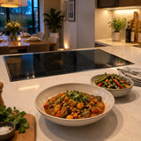 Finished vegetable dinner ready to serve beside the switched-off Kaiser La Perle five-zone induction hob.