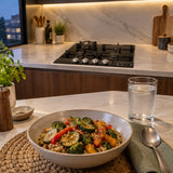 Finished warm grain bowl beside the switched-off Kaiser black glass gas hob in a contemporary kitchen.