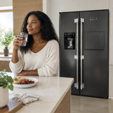 Glass of water ready beside a closed Kaiser black stainless steel refrigerator in a contemporary kitchen