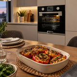 Finished stuffed peppers served near a closed Kaiser black built-in electric oven in a contemporary kitchen