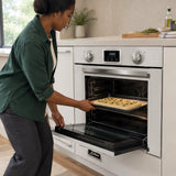 African American home cook loading focaccia dough into the Kaiser 79L white and black electric oven for hot-air baking