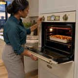 African American home cook using the Kaiser ivory gas oven's infrared grill to brown a vegetable dish.