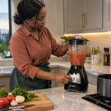 African American home cook using the Decakila stand blender to pulse-blend tomato sauce in a modern kitchen