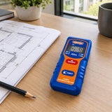 Wadfow laser distance meter resting beside an interior fitting plan on a contemporary work desk.