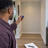 African American interior fitter using a Wadfow WDL1504 laser distance meter to measure an apartment alcove.