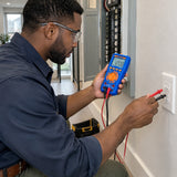 Qualified electrician using a Wadfow WDM2502 multimeter to check voltage at a residential wall receptacle