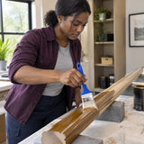 African American furniture refinisher using a Wadfow 63mm oil-based paint brush on a prepared timber handrail