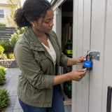 African American homeowner locking a garden shed hasp with a Wadfow 55mm weatherproof padlock