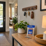 Completed entryway key rail secured to the wall with a Wadfow grey wall-anchor pack resting on the console below