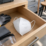 Unused Wadfow WDK2902 dust mask resting in a clean PPE drawer beside a contemporary renovation workspace.