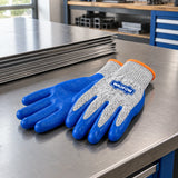 Wadfow XL cut-resistant gloves resting beside neatly stacked sheet metal on a clean fabrication bench.