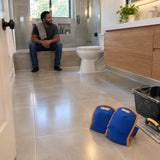Finished contemporary bathroom floor with Wadfow blue kneepads resting nearby after tiling work.