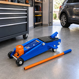 Wadfow WHJ2531 hydraulic floor jack parked with its handle in an organised contemporary home garage.
