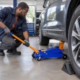 African American automotive technician uses the Wadfow WHJ2531 floor jack to begin lifting a vehicle at a designated service point.