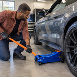 African American automotive enthusiast uses the Wadfow WHJ2535 low-profile floor jack beneath a low-clearance coupe in a clean workshop.