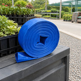 Coiled Wadfow blue lay-flat hose stored in an organised nursery irrigation area