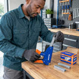 African American repair technician loading a Wadfow WNA0708 staple strip into a compatible staple gun at a workshop bench