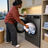 African American adult loading bed linen into a Luxell 8kg front-load washing machine in a contemporary laundry room.