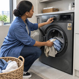 African American adult loading clothes and towels into a Luxell front-load washer-dryer and selecting a wash-and-dry setting
