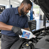 Automotive technician carefully adds ABRO Dexron III/Mercon fluid to a compatible automatic transmission