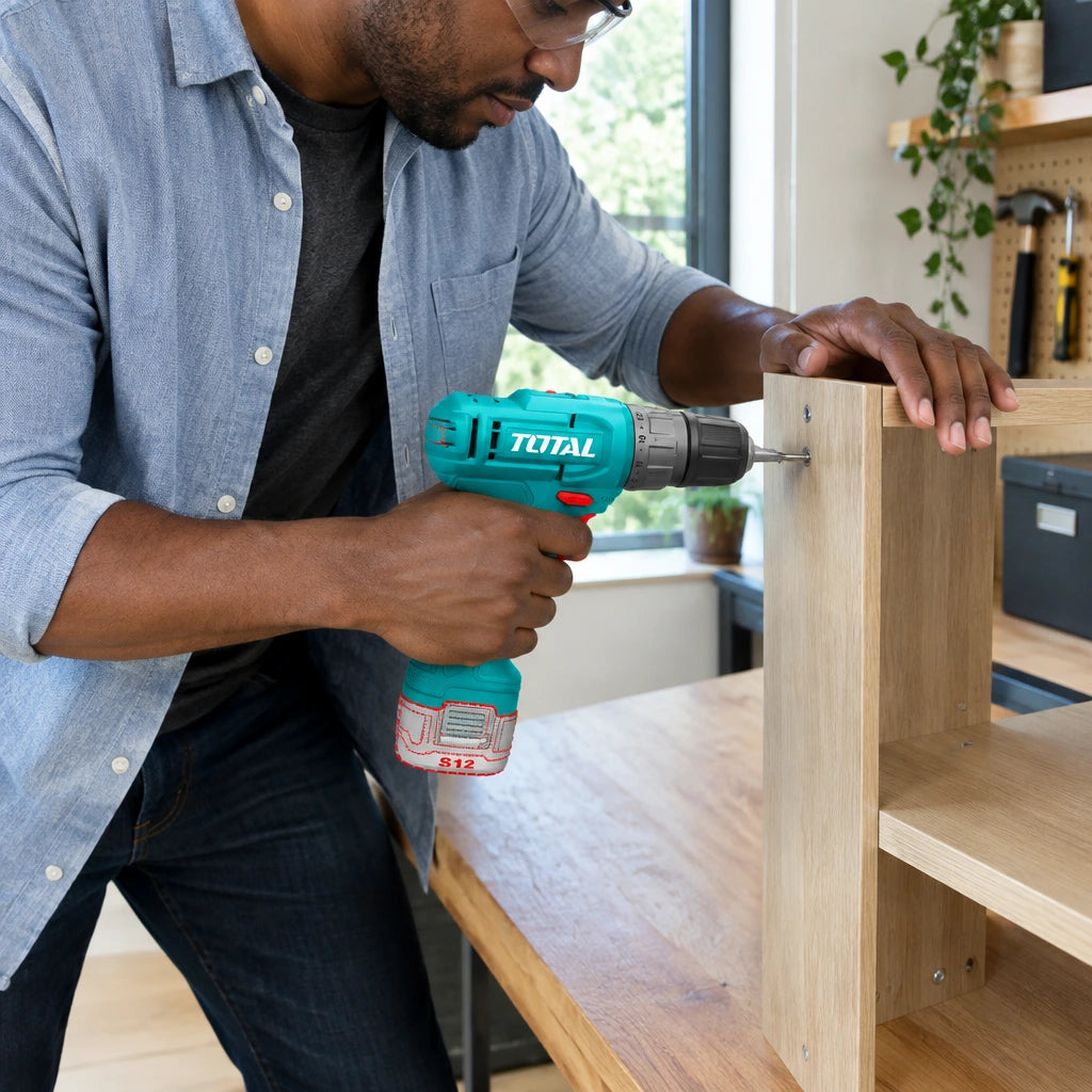 African American adult uses the Total TDLI12456 cordless drill to assemble a timber entry console