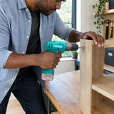 African American adult uses the Total TDLI12456 cordless drill to assemble a timber entry console