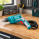 Total TD45658 corded electric drill resting on an organised home utility-room workbench