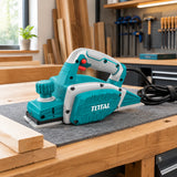 Total electric planer resting on an organised joinery workbench beside timber boards