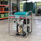 Total TP5406 diesel water pump parked in an organised commercial nursery equipment bay near a water-storage tank.