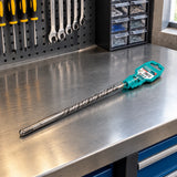 Packaged Total 6 × 260 mm SDS Plus masonry drill bit resting on an organised maintenance workshop bench