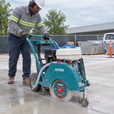 African American concrete contractor guides a gasoline floor saw using the Total TAC2144053 diamond disc to wet-cut a straight slab joint.