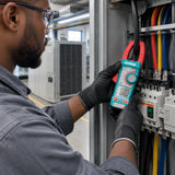 Electrical technician using the Total TMT762002 clamp meter around a single insulated conductor in a plant room