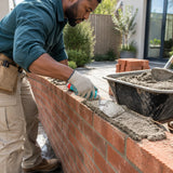 African American bricklayer using the Total THT82816 200mm trowel to spread mortar along a brick garden wall