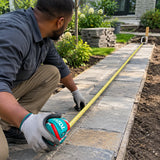 African American landscape installer using a Total 20m steel measuring tape to check a garden path length.