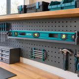 Total 120cm magnetic spirit level resting in organised long-tool storage in a professional workshop