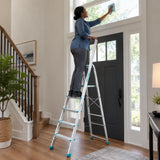 African American homeowner safely uses the Total five-step aluminium ladder to clean a tall entryway window