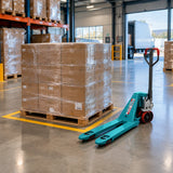 Completed warehouse dispatch bay with a staged pallet and Total THT301301 hand pallet truck resting nearby.
