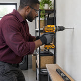 African American installer using the Ingco CIDLI208689 cordless impact drill with a masonry bit on a utility-room wall