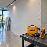 Completed gypsum-board partition with the Ingco cordless drywall screwdriver kit resting nearby