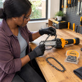 African American home gardener fitting an Ingco 5-inch replacement chain onto a compatible cordless pruning saw at a workshop bench.