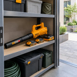 Ingco cordless air blower kit stored with its batteries and charger in an organised facilities cupboard beside a courtyard