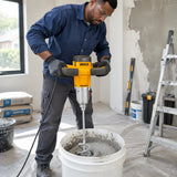 African American decorator using the Ingco MX516006 electric mixer to prepare wall coating in a renovation room